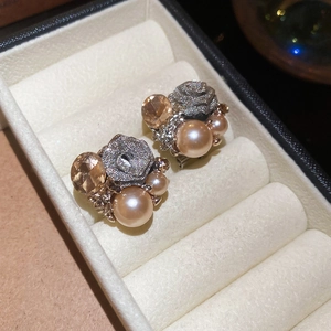 Close-up of rose flower earrings with champagne pearls and amber faceted crystals