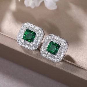 Macro shot of square emerald green cubic zirconia earrings with double halo diamonds
