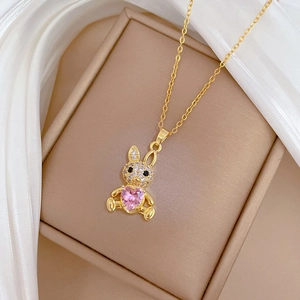 Detail of gold rabbit necklace with pavé diamonds and pink heart-shaped crystal stone