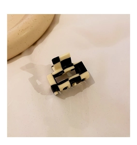 Close-up of a square checkerboard pattern hair claw clip with glossy finish