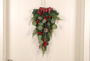 Hanging eucalyptus Christmas door decor with red berries and black-red buffalo plaid bow