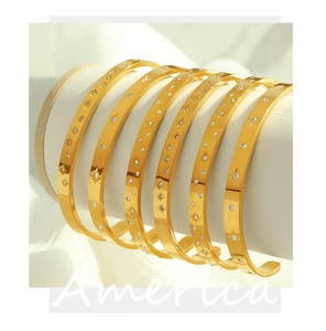 Macro view of 7-piece 18K gold plated zircon bangles with starburst patterns on a stand