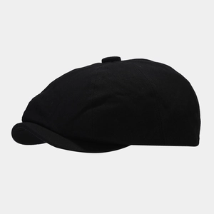 Detailed side view of classic black cotton newsboy cap with octagonal stitch structure