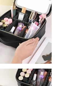 Detail of large black makeup case with adjustable dividers and built-in mirror