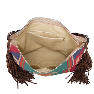 Detail of bohemian woven tote bag interior showing zipper pocket and brown leather tassels