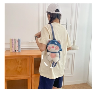 Detail view of a cute blue and white plush cat-shark backpack worn by a model in a cozy room