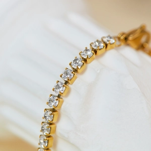 Macro view of gold plated stainless steel tennis bracelet with sparkling cubic zirconia