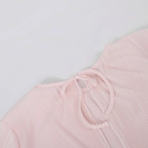 Close-up of pink pleated fabric showing neck opening and delicate lace-up tie detail