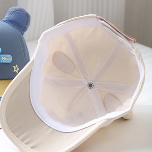 Vue intérieure de la casquette bébé montrant le coton respirant et les coutures