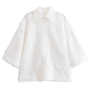 Ensemble chic blanc avec chemise à plumes et franges et jupe en tissu texturé