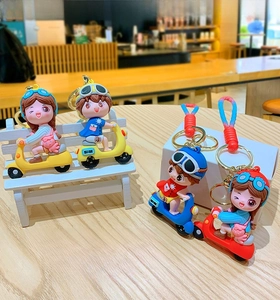 Detailed view of four colorful cartoon scooter boy and girl keychains on a mini bench