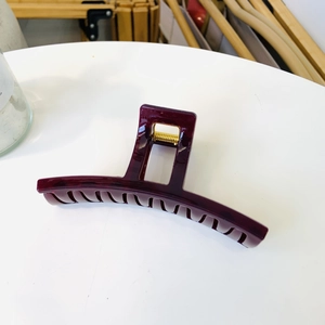 Detail of a large deep purple hair claw clip with a durable golden metal spring