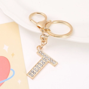 Detail of gold-plated letter T keychain featuring shimmering rhinestones and clasp