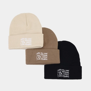 Three oversized knitted beanies with positive embroidery in beige, brown, and black colors