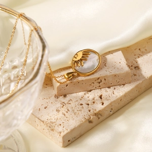 Gros plan détaillé d'un collier en acier inoxydable doré 18K avec pendentif soleil en nacre
