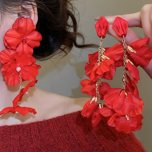 Detail of red fabric flower earrings with white pearls and gold metal leaves