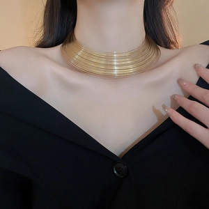 Close-up of golden multilayer metal choker necklace on model showing bold geometric design