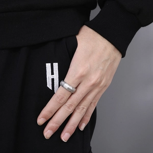 Macro detail of men's matte brushed titanium steel ring with industrial tiered structure