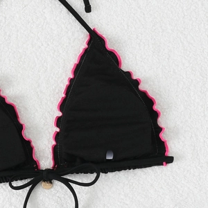 Close-up of bikini top with pink ruffle trim, removable pads, and gold brand tag