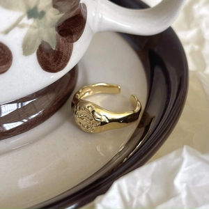 Macro detail of gold 925 sterling silver ring with hammer texture on ceramic tray