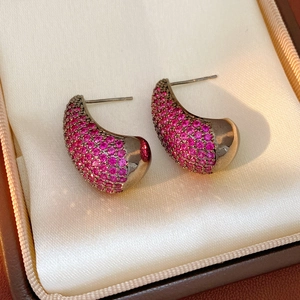Close-up of vintage gun-black arc earrings with pavé set purple cubic zirconia stones