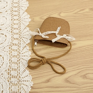 Close-up of girls woven straw bag with elegant white lace bows and fine shoulder strap