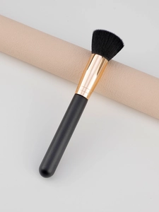 Detailed shot of dense black flat-top powder brush with gold ferrule and matte handle