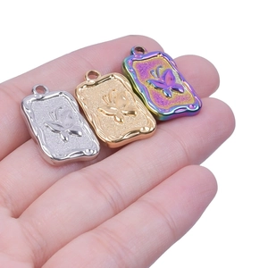 Detailed close-up of rectangular butterfly charms in silver, gold, and rainbow finishes