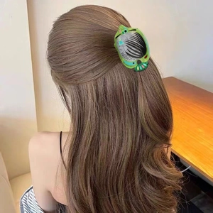 Green acetate hair claw clip for high ponytail shown on model with brown wavy hair