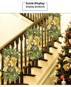 Close-up of golden Christmas staircase swag with LED lights, pine cones, and silk bows