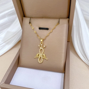 Luxurious gold titanium necklace with angel wing and infinity pendant on silk background