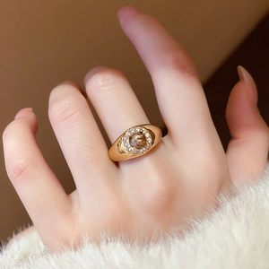 Detailed close-up of a vintage golden signet ring with zircon wheat ear accents on a hand