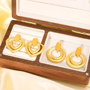Gold double-layered heart and circular dangle earrings in a luxury jewelry box