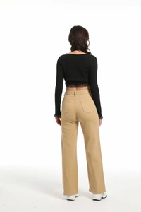 Vue de dos d'un pantalon beige taille haute à jambes larges et d'un haut en dentelle noire