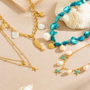 Gold stainless steel necklace with ocean charms like starfish, shells, and turquoise beads