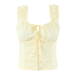 Detailed flat lay of a yellow sleeveless floral crop top with ruffles and front buttons