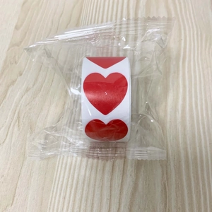 Detail view of red heart stickers in a roll, individually packed in transparent plastic