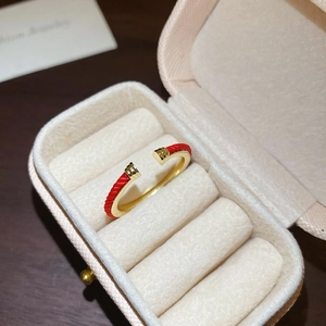 Macro shot of minimalist red rope and gold snake ring inside a jewelry box