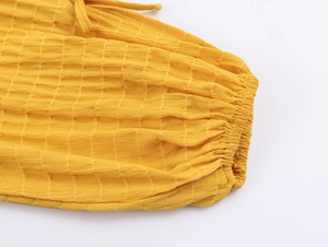 Vista macro dettagliata dei polsini elastici a quadretti gialli con elegante design a lacci