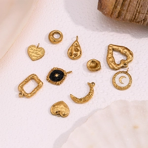 Makroaufnahme von 18K vergoldeten Himmelsanhängern mit Stern- und Mond-Emaille-Details