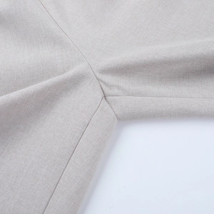 Macro di pantaloni in lino a vita alta che mostrano cuciture pulite e trama tessuta