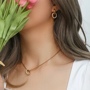 Fashion jewelry set with golden interlocking circles and sparkling zircons on a model
