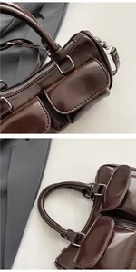 Detail shot of vintage dark brown glossy handbag with front flap pockets and metal hardware