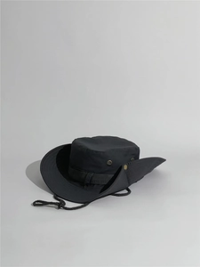 Close-up of black sun hat featuring breathable metal vents and adjustable chin strap