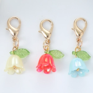 Detail of lily of the valley keychains with pearl petals, green leaves and gold lobster clasps
