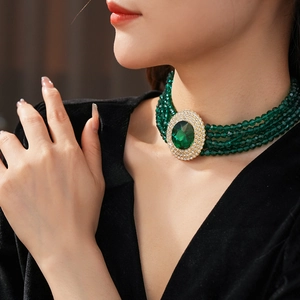 Detail of green beaded multilayer necklace with emerald faux gemstone pendant and rhinestones