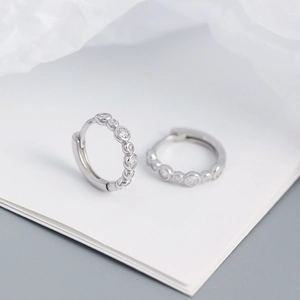 Macro shot of S925 sterling silver hoop earrings with channel-set clear cubic zirconia