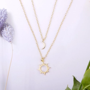 Détail du collier double couche soleil et lune en acier inoxydable doré sur blanc