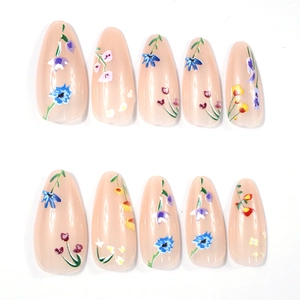 Detailed set of almond press-on nails with small colorful floral patterns on nude base