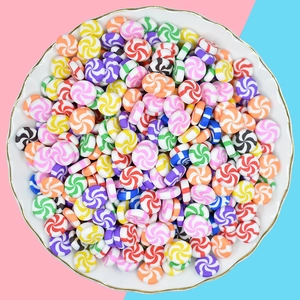 Miniature colorful swirl lollipop resin charms for DIY crafts in a white ceramic dish